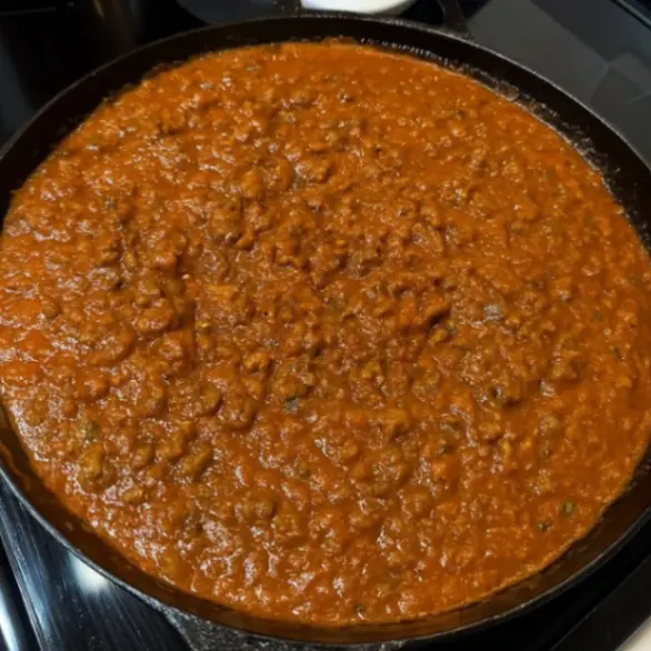 Thick and hearty ground beef marinara sauce simmering in a pan, perfect for pasta, lasagna, or baked dishes.